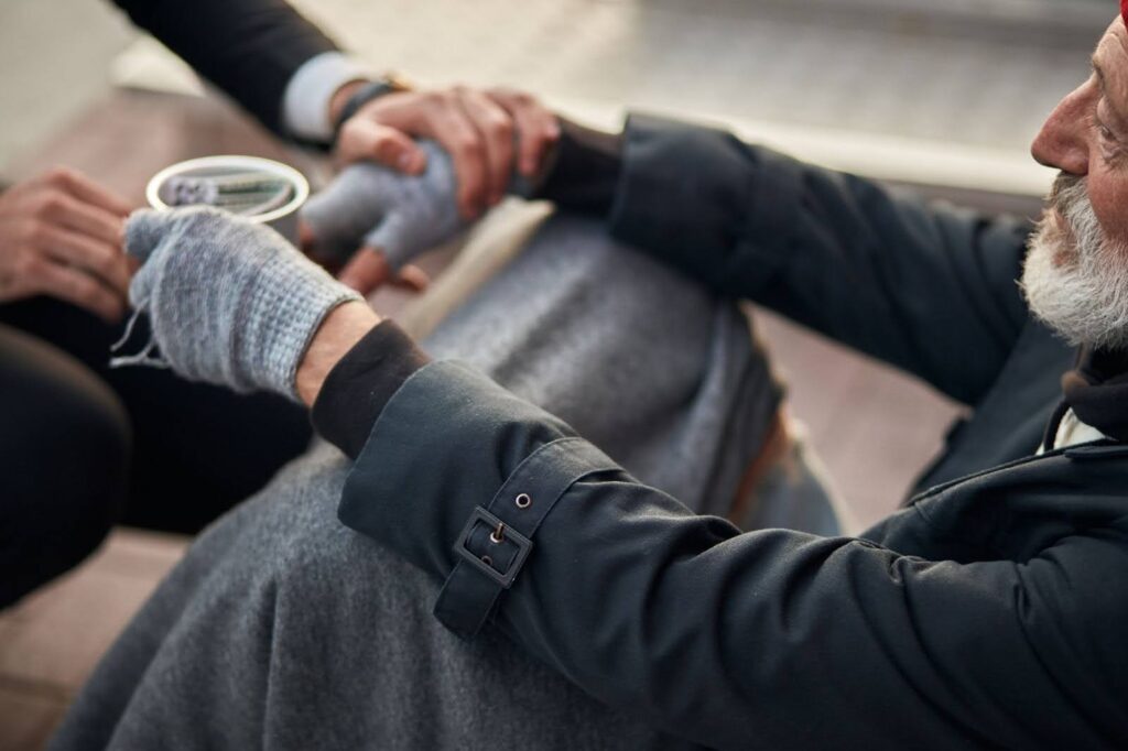 Caring man helping a person experiencing homelessness
